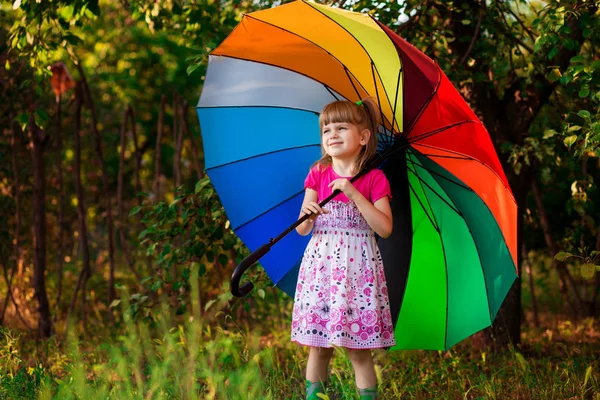 秋の雨の下で色とりどりの傘で歩く幸せな子供女の子 — ストック写真