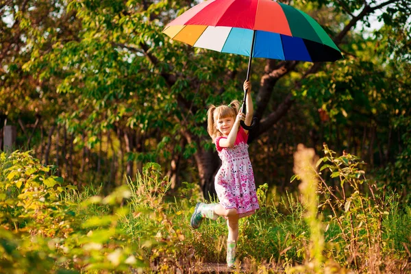 秋の雨の下で色とりどりの傘で歩く幸せな子供女の子 — ストック写真