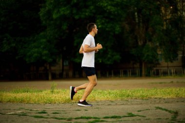 Doğa akşamları koşan atletik genç adam.