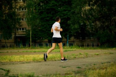 Doğa akşamları koşan atletik genç adam.