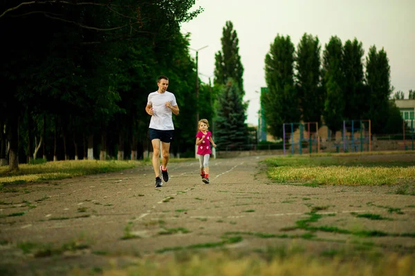Спортивний Молодий Батько Маленька Дочка Бігають Стадіоні Заході Сонця Здоровий — стокове фото