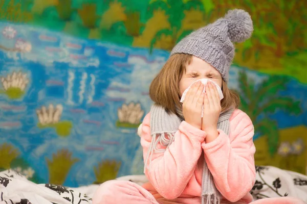 Little girl with runny nose wipes her nose, health concept