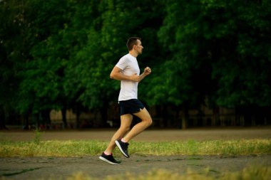 Doğa akşamları koşan atletik genç adam.