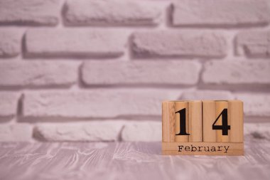 Beyaz tuğla arka plan ile ahşap takvim üzerinde 14 Şubat ayarla.