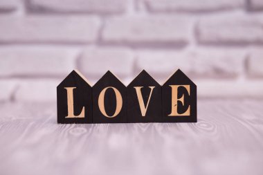 Metin seviyorum beyaz tuğla arka plana sahip siyah ahşap bloklar.