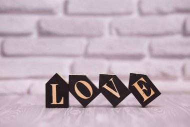 Metin seviyorum beyaz tuğla arka plana sahip siyah ahşap bloklar.