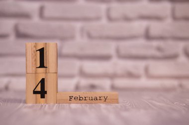 Beyaz tuğla arka plan ile ahşap takvim üzerinde 14 Şubat ayarla.