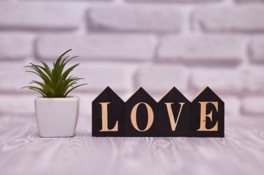 Metin güzel oyuncak çiçek beyaz tuğla zemin üzerine siyah ahşap bloklar üzerinde seviyorum.