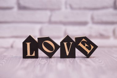 Metin seviyorum beyaz tuğla arka plana sahip siyah ahşap bloklar.