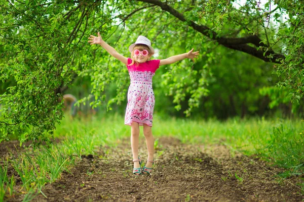 Счастливая Маленькая Девочка Ярком Платье Забавных Солнцезащитных Очках Ходить Саду — стоковое фото