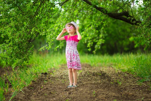 Happy Mrňavá Holka Světlé Šaty Legrační Brýle Procházka Zahradě — Stock fotografie