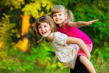 Birlikte oynayan iki çocuk kız. Sisters süper kahraman çal. Mutlu çocuklar eğleniyor, gülümseyen ve sarılma. Aile tatili ve birliktelik. Kız güç kavramı