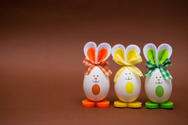 Çok renkli komik yumurta şeklinde tatlı bunny kahverengi zemin üzerinde. Mutlu paskalyalar. Festival dekorasyon