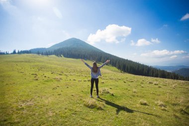 Eller yukarı tepenin üstüne Hiking kız dağ manzaralı keyfini çıkarın. Seyahat kavramı