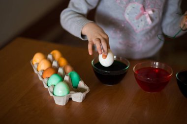Mutlu paskalyalar. Küçük kız ressam yumurta boyalı. Çocuk Paskalya için hazırlanıyor. Boyalı el. Sanat ve el sanatları kavramı. Geleneksel bahar tatil gıda