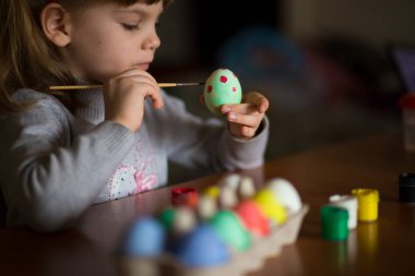 Mutlu paskalyalar. Küçük kız ressam yumurta boyalı. Çocuk Paskalya için hazırlanıyor. Boyalı el. Sanat ve el sanatları kavramı. Geleneksel bahar tatil gıda
