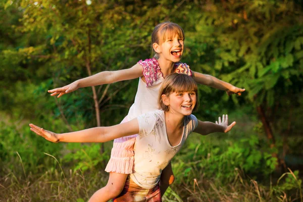 Twee kind meisjes samenspelen. Zusters spelen superheld. Happy kids plezier, glimlachend en knuffelen. Vakantie met het gezin en saamhorigheid. — Stockfoto