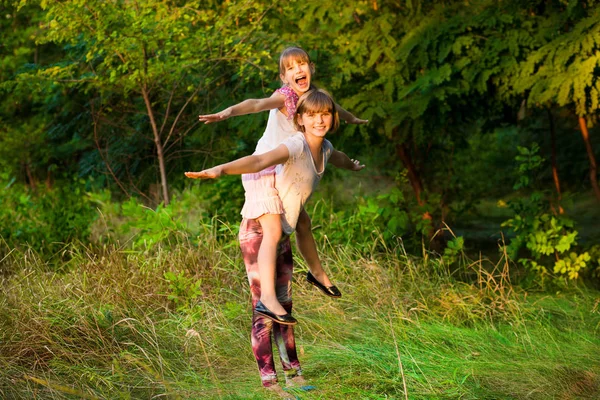 Duas meninas brincando juntas. As irmãs fazem de super-heróis. Crianças felizes se divertindo, sorrindo e abraçando. Férias em família e união . — Fotografia de Stock