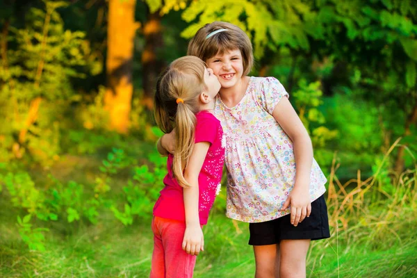 Little girl is very happy that she has sister. Loving sister hugging cute little girl showing love care support. Sincere warm relationships. Concept of happy family, adoption, foster sister.