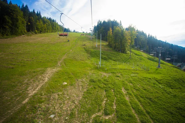 Emtpy felvonó ski resort. Hegyek és dombok, a zöld fák nyáron — Stock Fotó