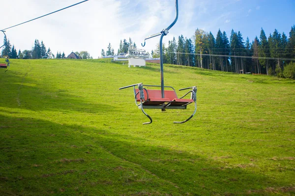 Seggiovia Emtpy nella stazione sciistica. Montagne e colline con in estate con alberi verdi — Foto Stock