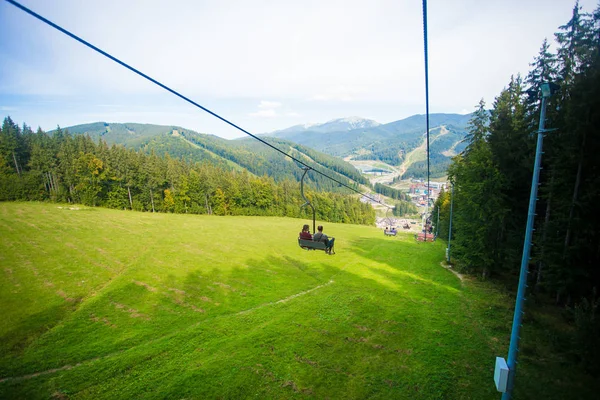 Άνθρωποι που κάθονται στο chairlift καλοκαίρι πεζοπορία στα βουνά — Φωτογραφία Αρχείου