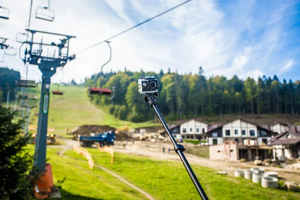 Câmera de ação no pau selfie no pico das montanhas — Fotografia de Stock