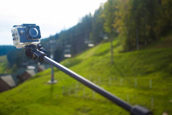 Cámara de acción en palo selfie en el pico de las montañas — Foto de Stock