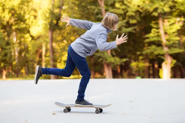 Sportliches junges Mädchen reitet auf Longboard im Park. — Stockfoto