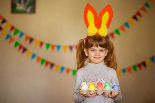 Sevimli küçük kız parlak Paskalya yortusu yumurta tutan tavşan kulakları ile — Stok fotoğraf
