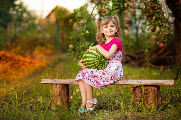 Gelukkig kind meisje houdt zeer grote watermeloen in zonnige dag. Gezond eten concept — Stockfoto