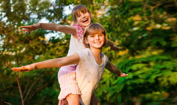 Dos niñas jugando juntas. Las hermanas juegan al superhéroe. Niños felices divirtiéndose, sonriendo y abrazándose. Vacaciones familiares y unión . —  Fotos de Stock