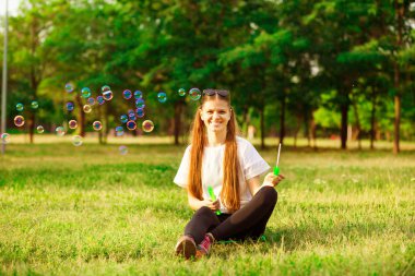 güzel genç kadın parkta balon üfleme beyaz