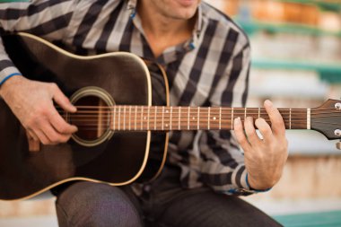 İskambil gitar ve şarkı, müzik konsepti basamaklarında oturan genç adam