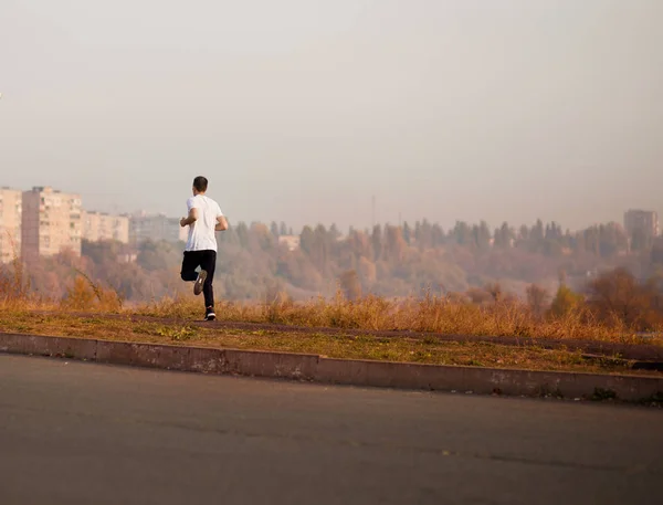 Чоловік біжить осіннім ранком. Здоровий спосіб життя — стокове фото