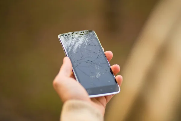 Joven hombre mantenga roto la pantalla del teléfono inteligente. Teléfono roto en la mano — Foto de Stock