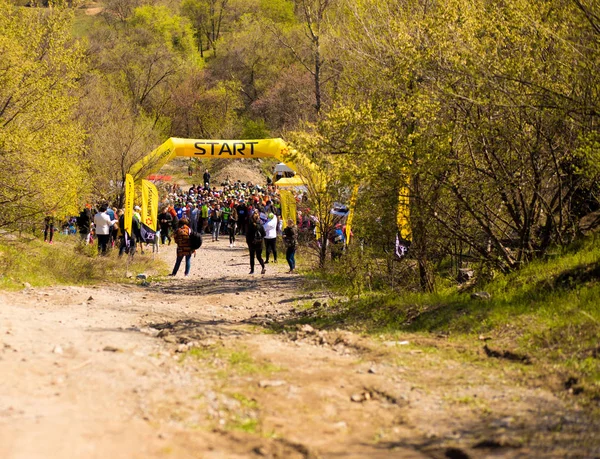 Krivoy Rog, Ucrania - 21 de abril de 2019: Grupo de jóvenes atletas en posición de inicio. Ajustar a los jóvenes que se preparan para los participantes de maratón inicio a distancia — Foto de Stock
