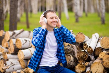 Parkta yürüyen akıllı telefonu kontrol müzik dinlerken kulaklık takan mutlu adam