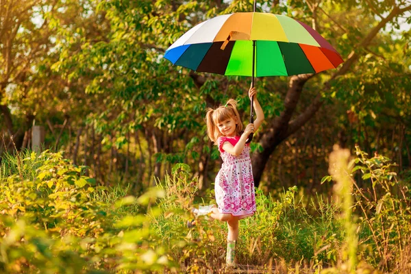 雨の下で色とりどりの傘で歩く幸せな子供女の子 — ストック写真