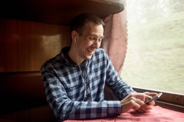 Tren istasyonunda iş seyahat onun akıllı telefon uygulama kullanan adam