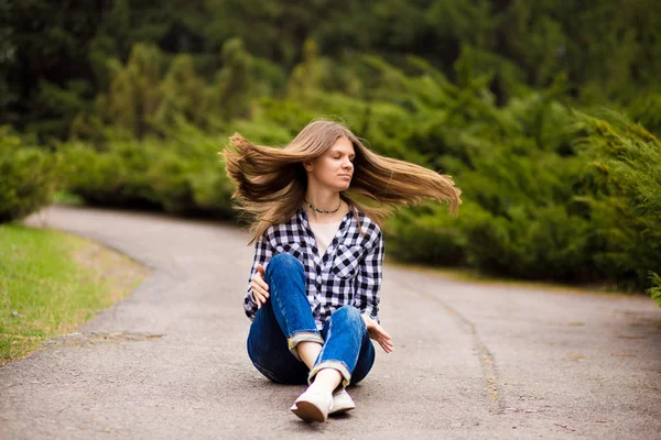 Lachende jonge vrouw in shirt en jeans ontspannen met Fly Hair — Stockfoto