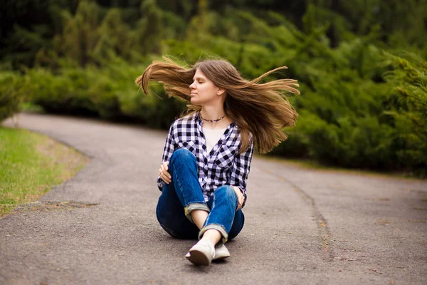 Lachende jonge vrouw in shirt en jeans ontspannen met Fly Hair — Stockfoto