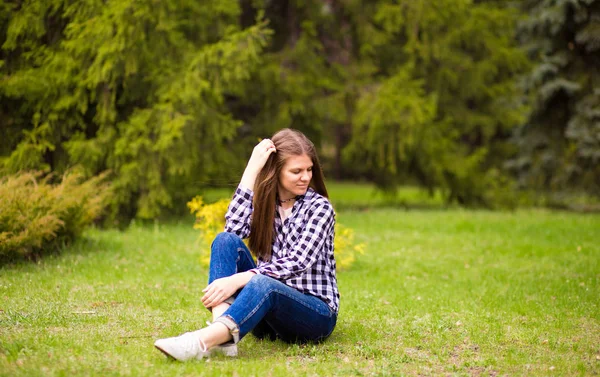 Aantrekkelijke jonge vrouw genieten van haar tijd buiten in park met zonsondergang in de achtergrond. — Stockfoto