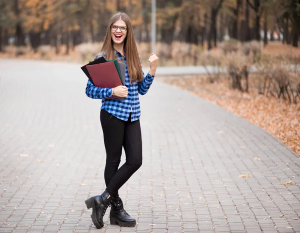 Sommarlov, utbildning, Campus och tonårs koncept-leende kvinnlig student i svarta glasögon med mappar — Stockfoto