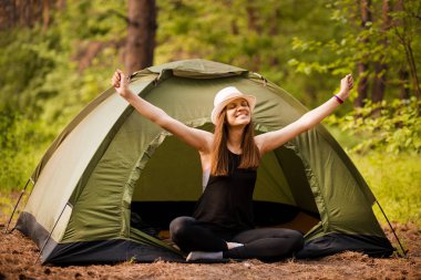 Çadır Dışında gün doğumu zevk elleri ile Mutlu hipster sevimli genç kız. ormanda kamp.