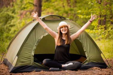 Çadır Dışında gün doğumu zevk elleri ile Mutlu hipster sevimli genç kız. ormanda kamp.