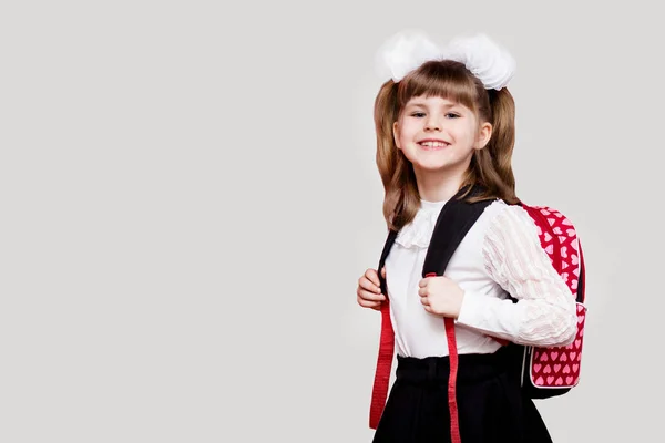 Felice ragazza bambino carino con sacchetto della scuola isolato su uno sfondo bianco. La prima volta a scuola. Ritorno a scuola . — Foto Stock