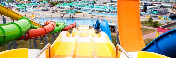 Sommarsemester banner färgglada plast rutschbanor i Aquapark i solljus — Stockfoto