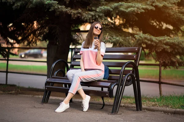 Git dans les lunettes de soleil assis sur le banc et boire du café — Photo