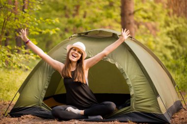 Çadır Dışında gün doğumu zevk elleri ile Mutlu hipster sevimli genç kız. ormanda kamp.